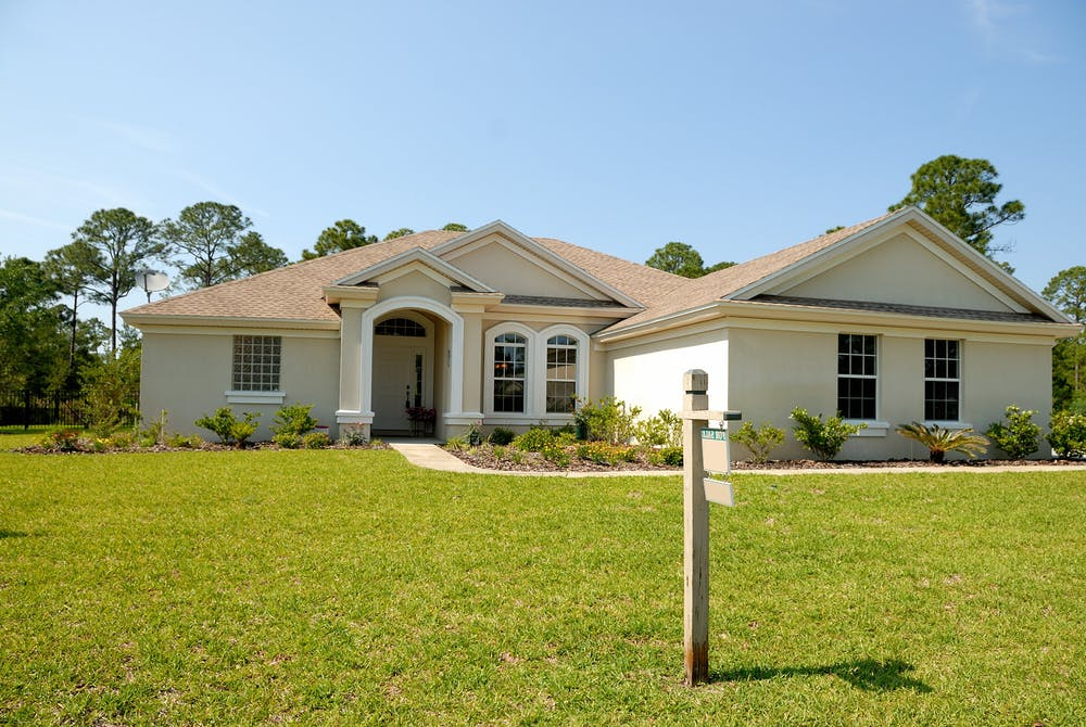 House with For Sale Sign in Front Yard